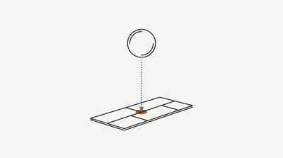A steel ball dropping onto a shingle in an impact resistance test